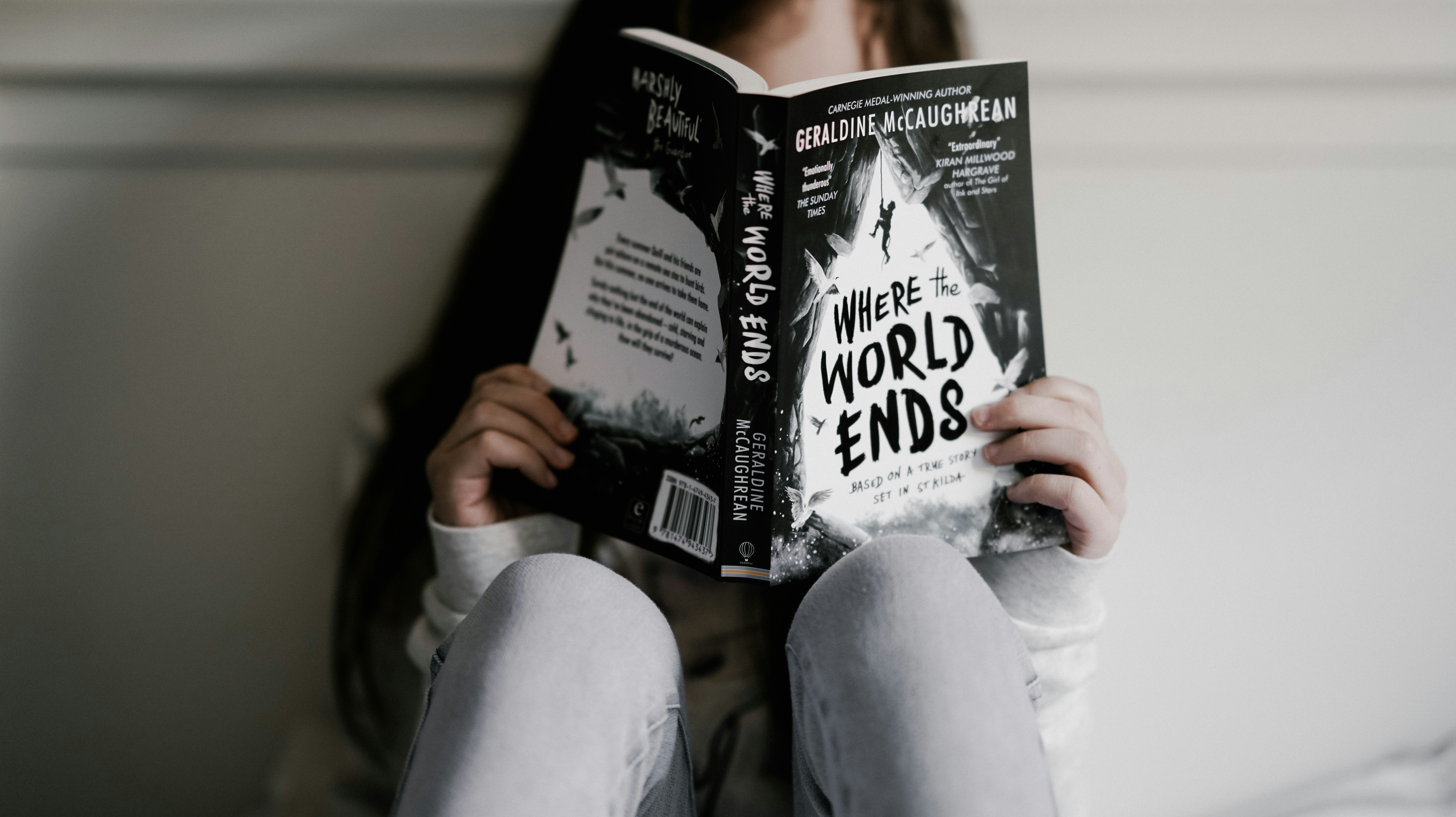 Girl reading book - where the world ends