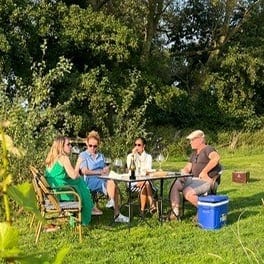 Groep van Auke aan de proeverijtafel tussen de wijnranken van Domein Bergen