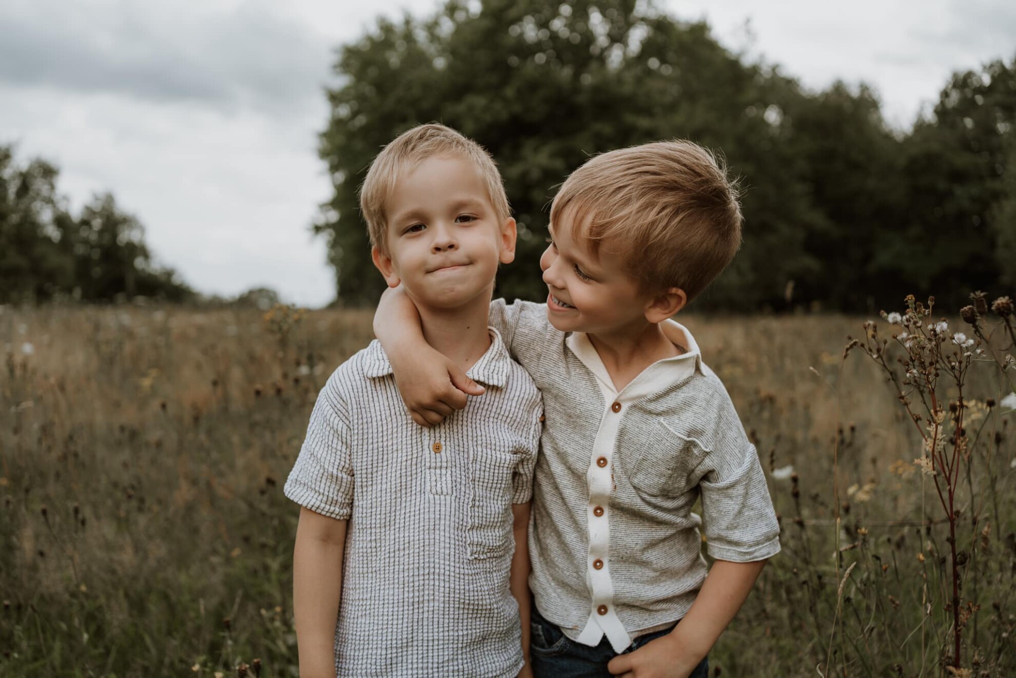 Twee jonge jongens arm in arm in een grasveld