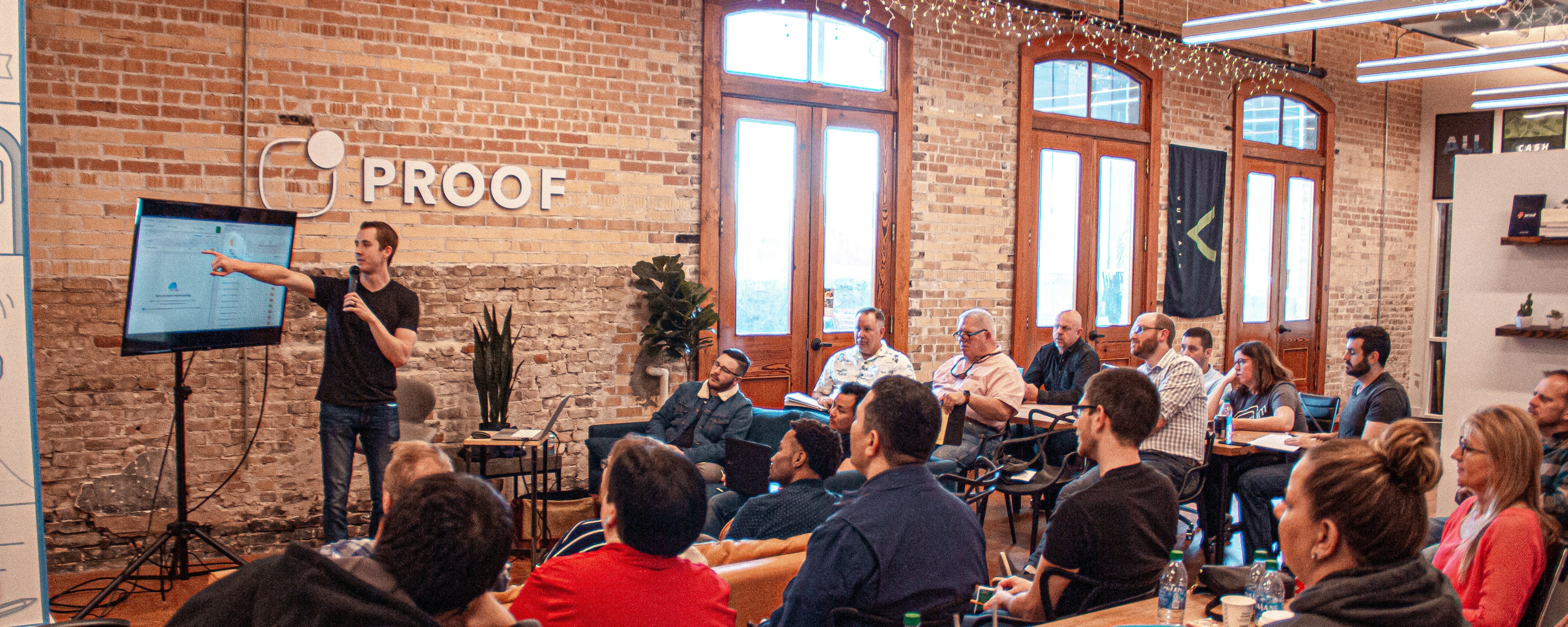 Man presenting power point to small audience in start-up office.