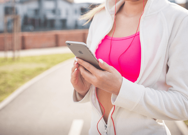 vrouwelijke hardloper luistert audio op smartphone