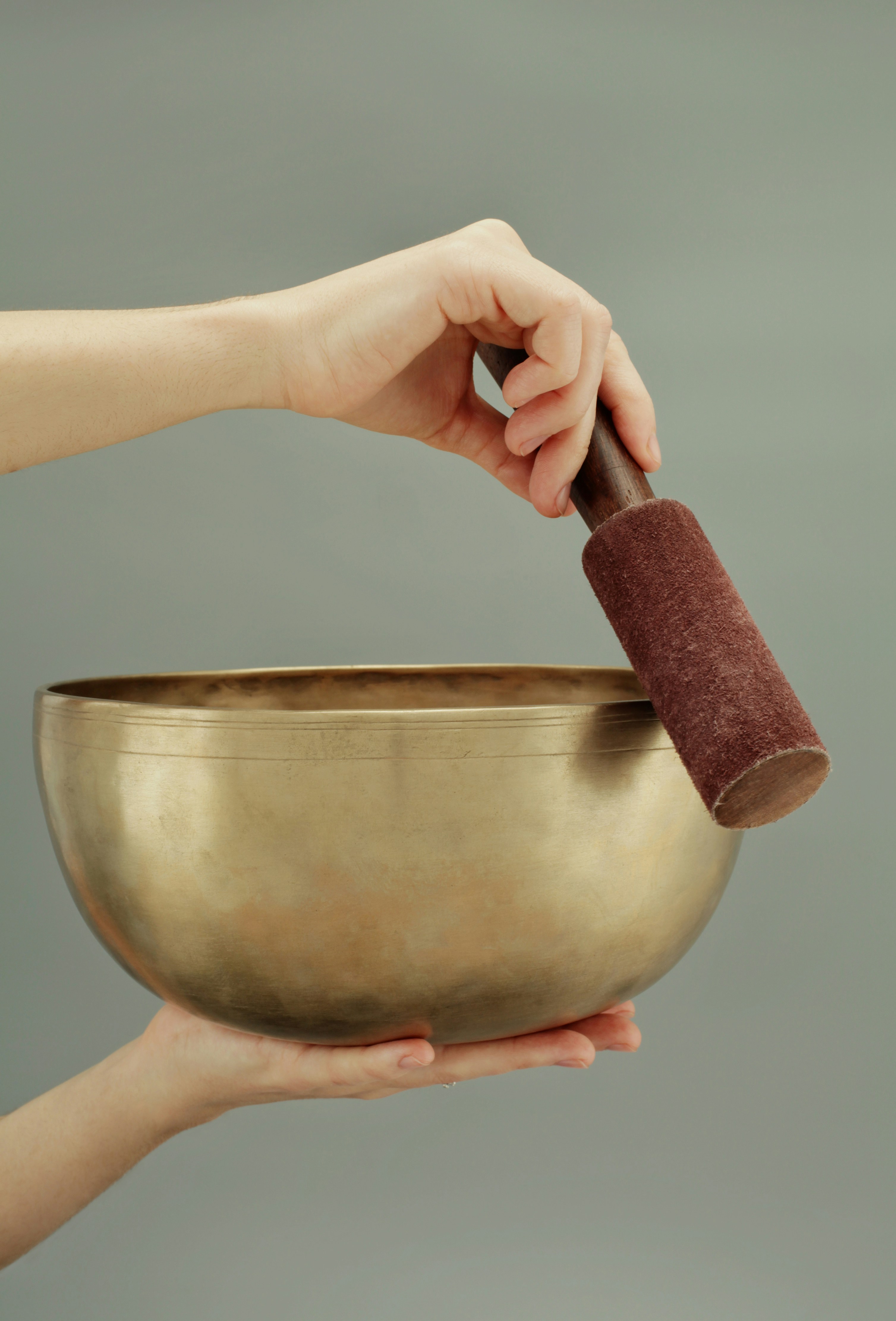 Tibetan singing bowls therapy. Big Tibetan singing bowl in the hands of a woman.