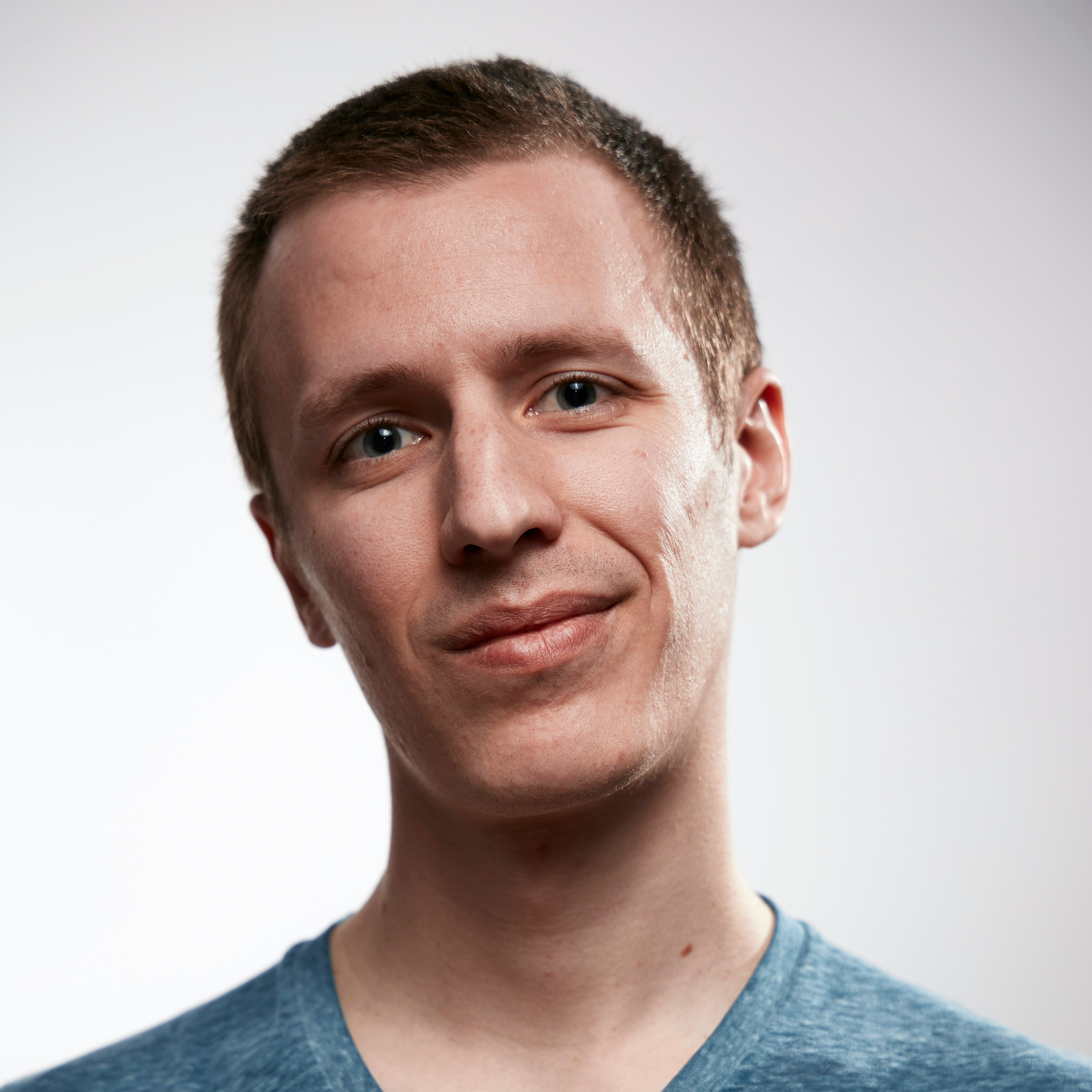 Portrait of a smiling man in casual blue shirt on a white background. Self portrait taken to test a brand new EOS RP.