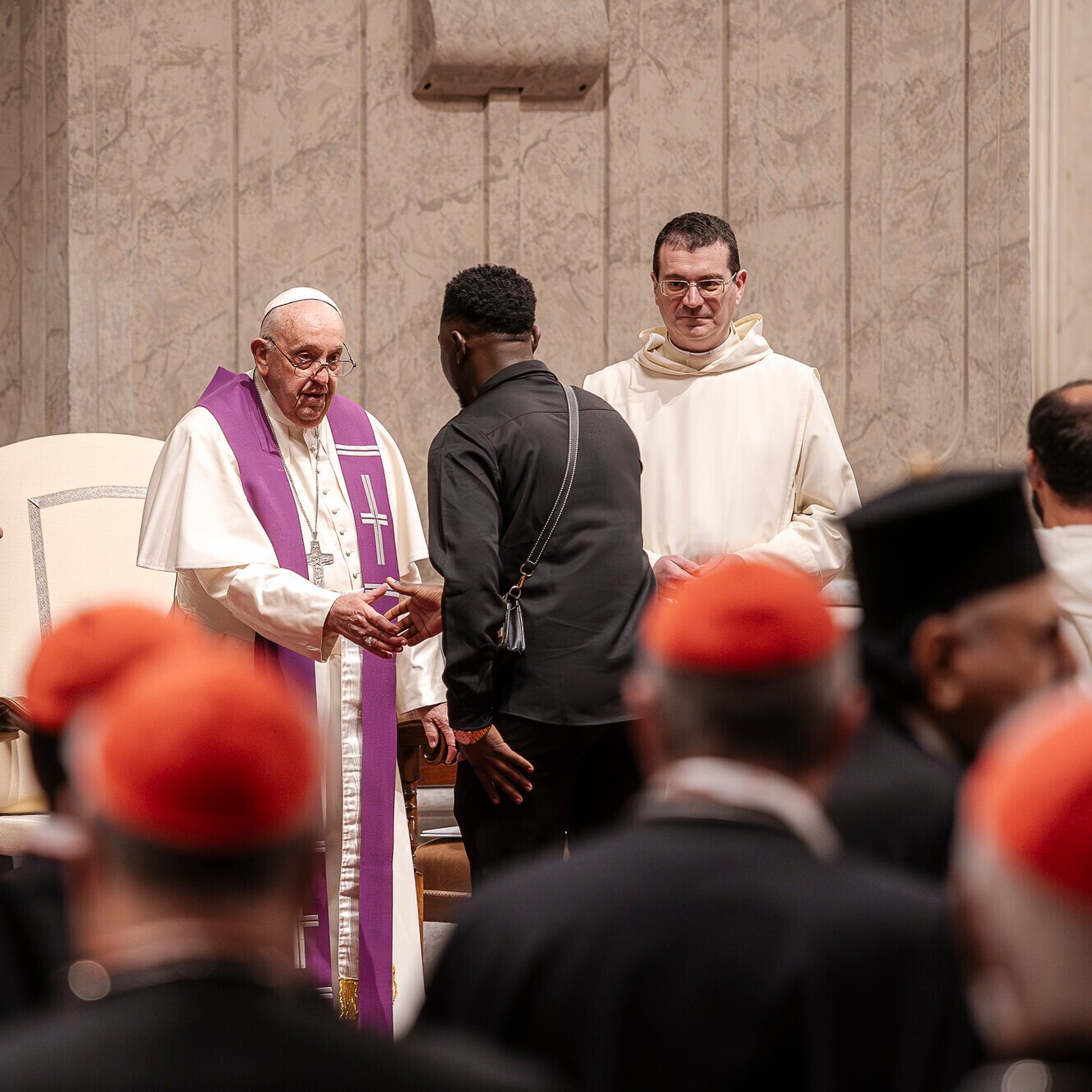 Paus Franciscus bij opening synode, schudt deelnemer uit Afrika de hand