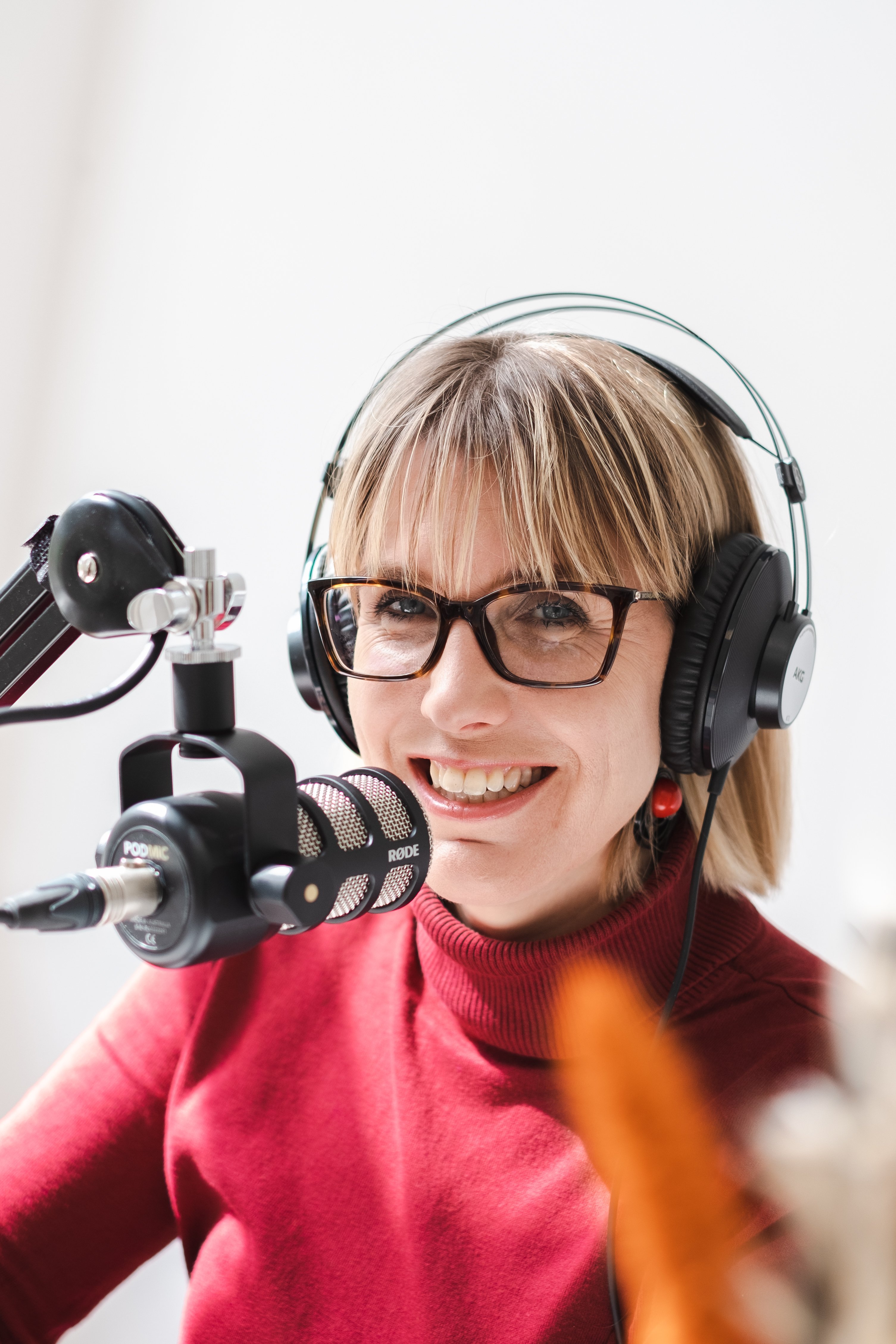 Vrouw lachend achter microfoon met koptelefoon op