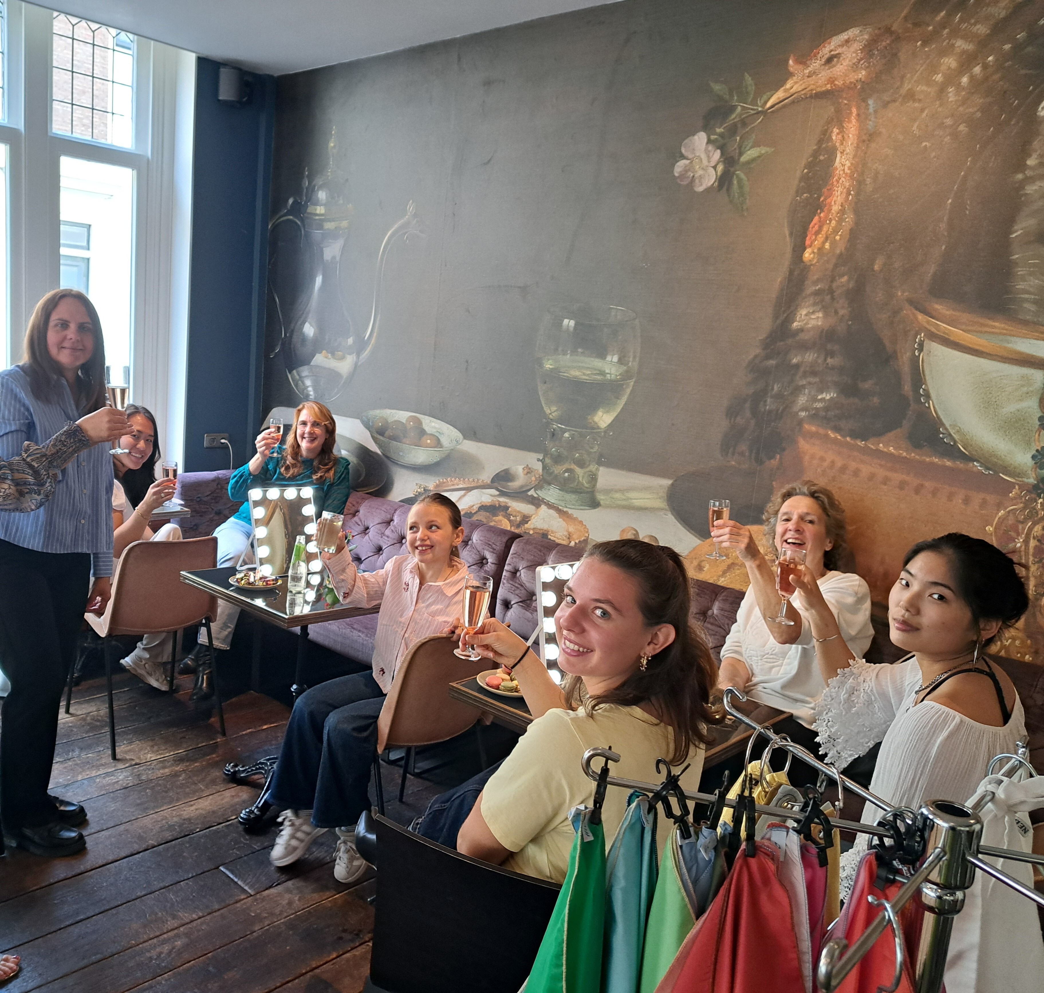 Groep vriendinnen proost met bubbels tijdens de kleurenworkshop bij Hotel Lion d'Or in Haarlem.