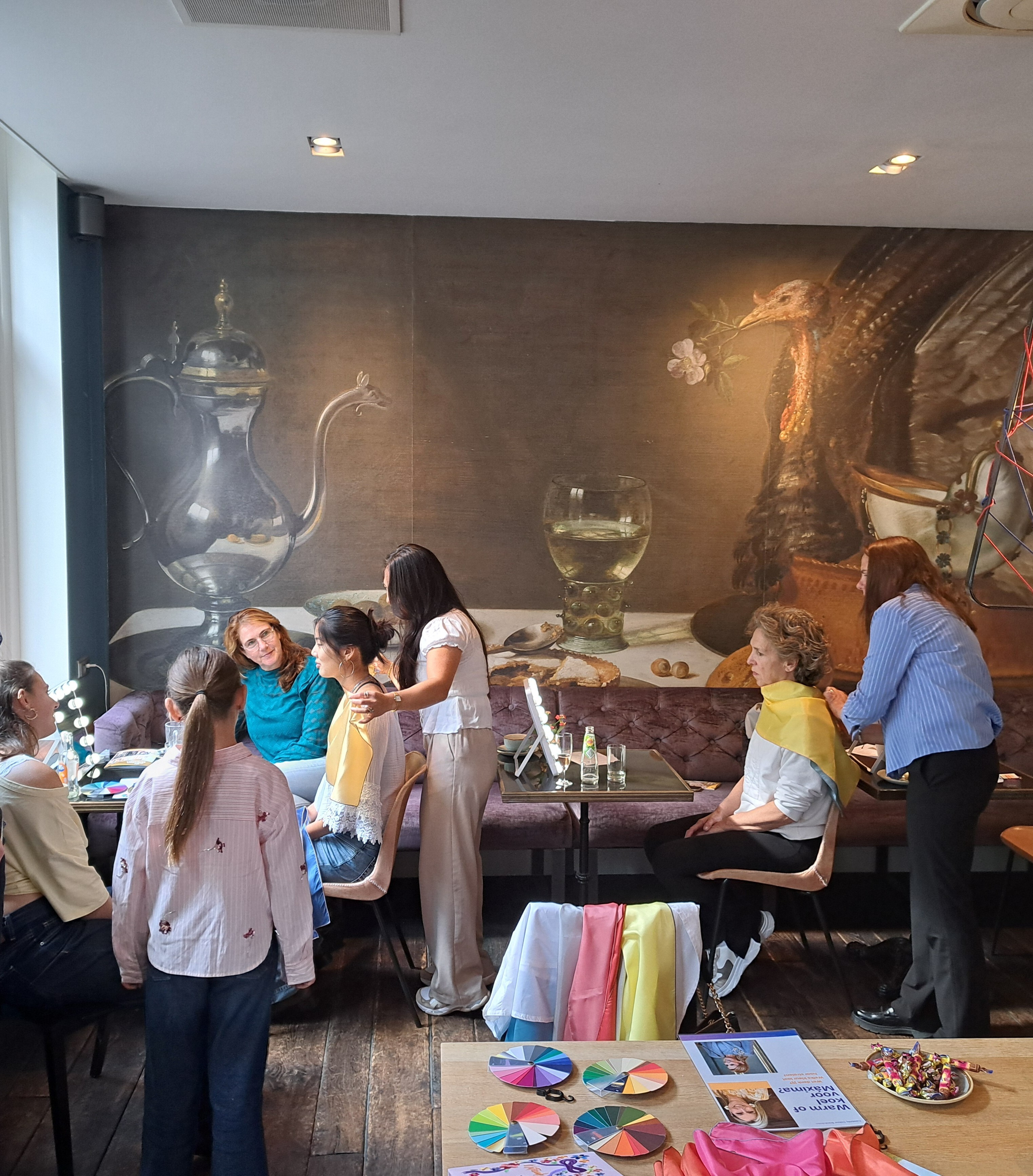 Een leuk en origineel uitje voor babyshower, teamuitje of bachelor party. Deelnemers kijken samen in de spiegel tijdens de kleurenanalyse workshop in de Lounge van Hotel Lion d'Or in Haarlem.