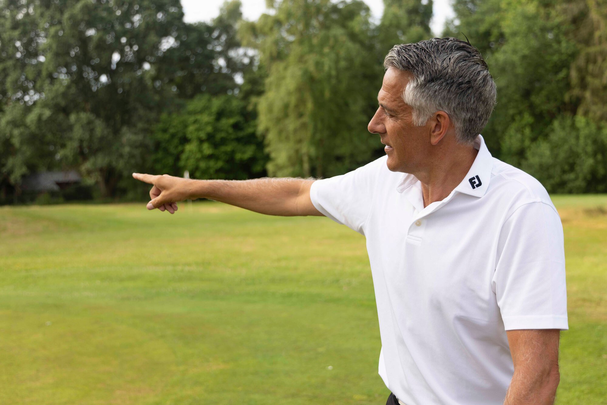 Golfprofessional Mike van Wieringen wijst richting op de golfbaan als symbool voor begeleiding en structuur