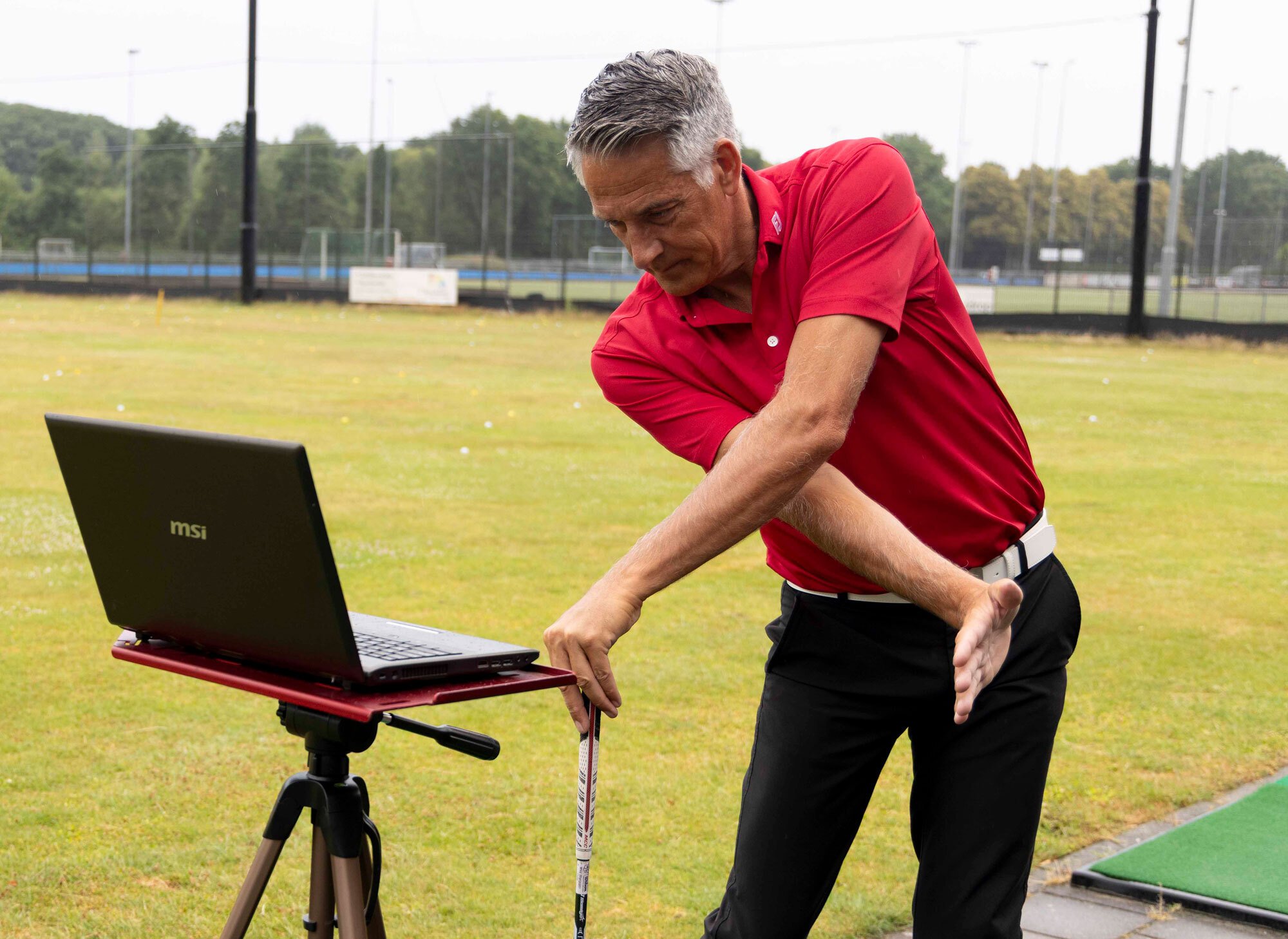 Golfpro Mike van Wieringen laat online lesmateriaal zien op een laptop – visuele uitleg binnen Golfwijzer Basic