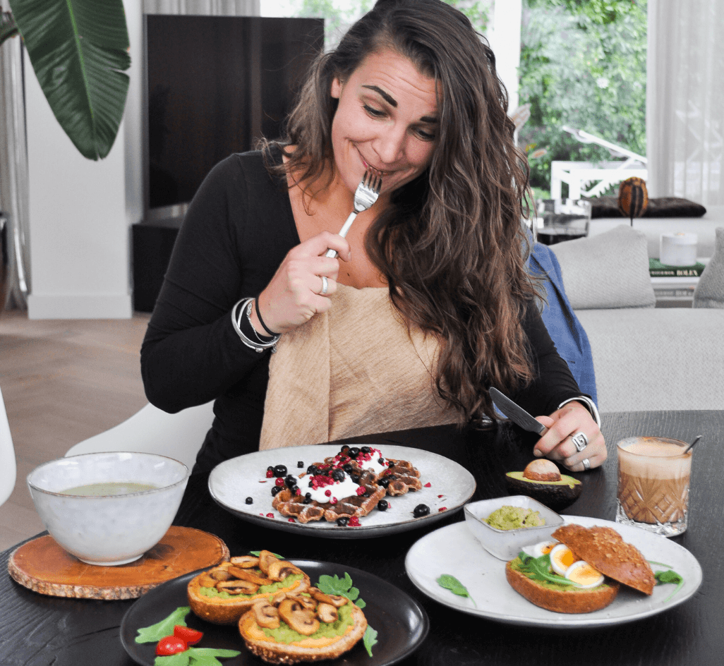 Vrouw die aan het eten is en aan het genieten, wafels en broodjes om beeld uit te stralen dat je kan genieten tijdens het afvallen