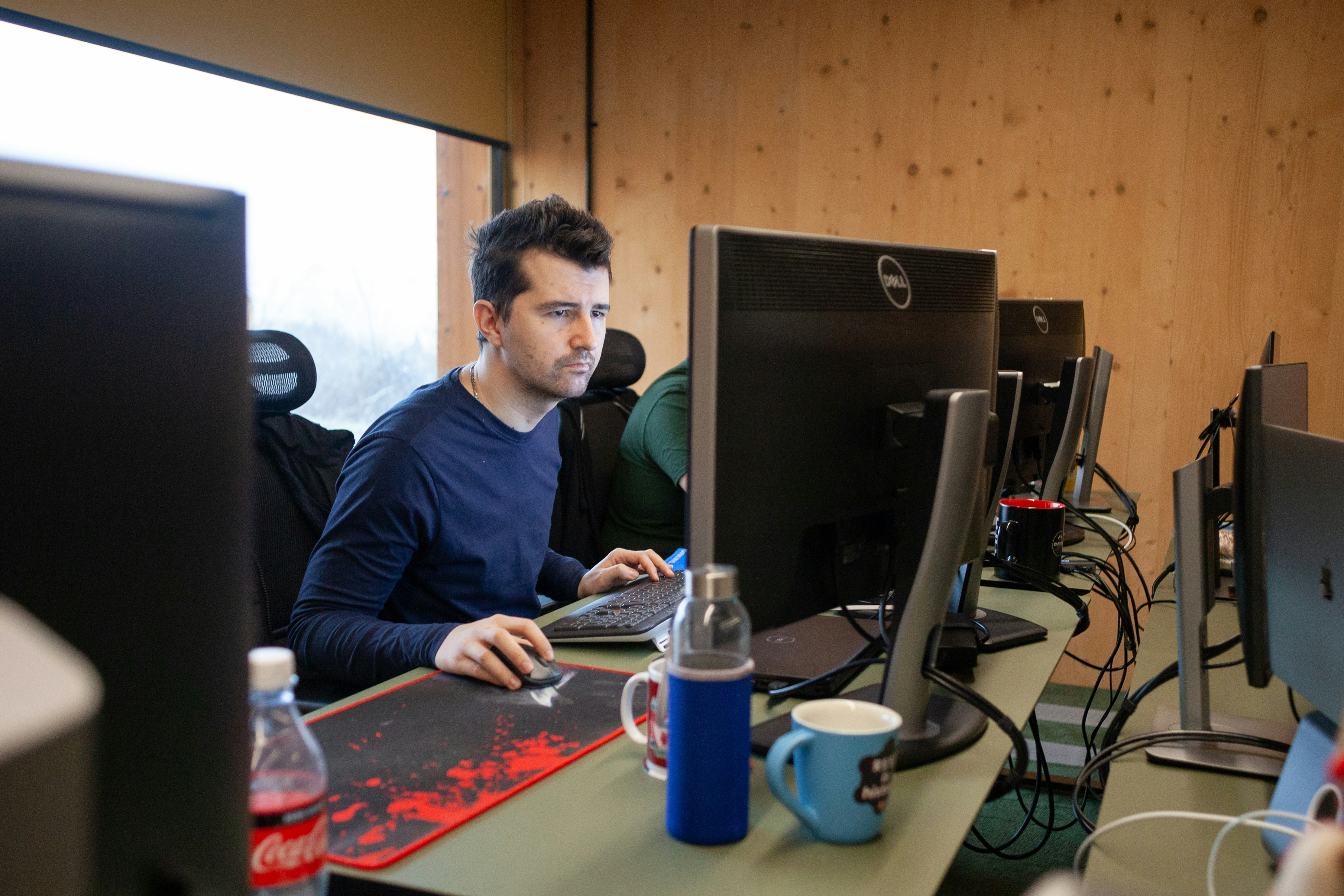 Focused man working on computer from office desk.