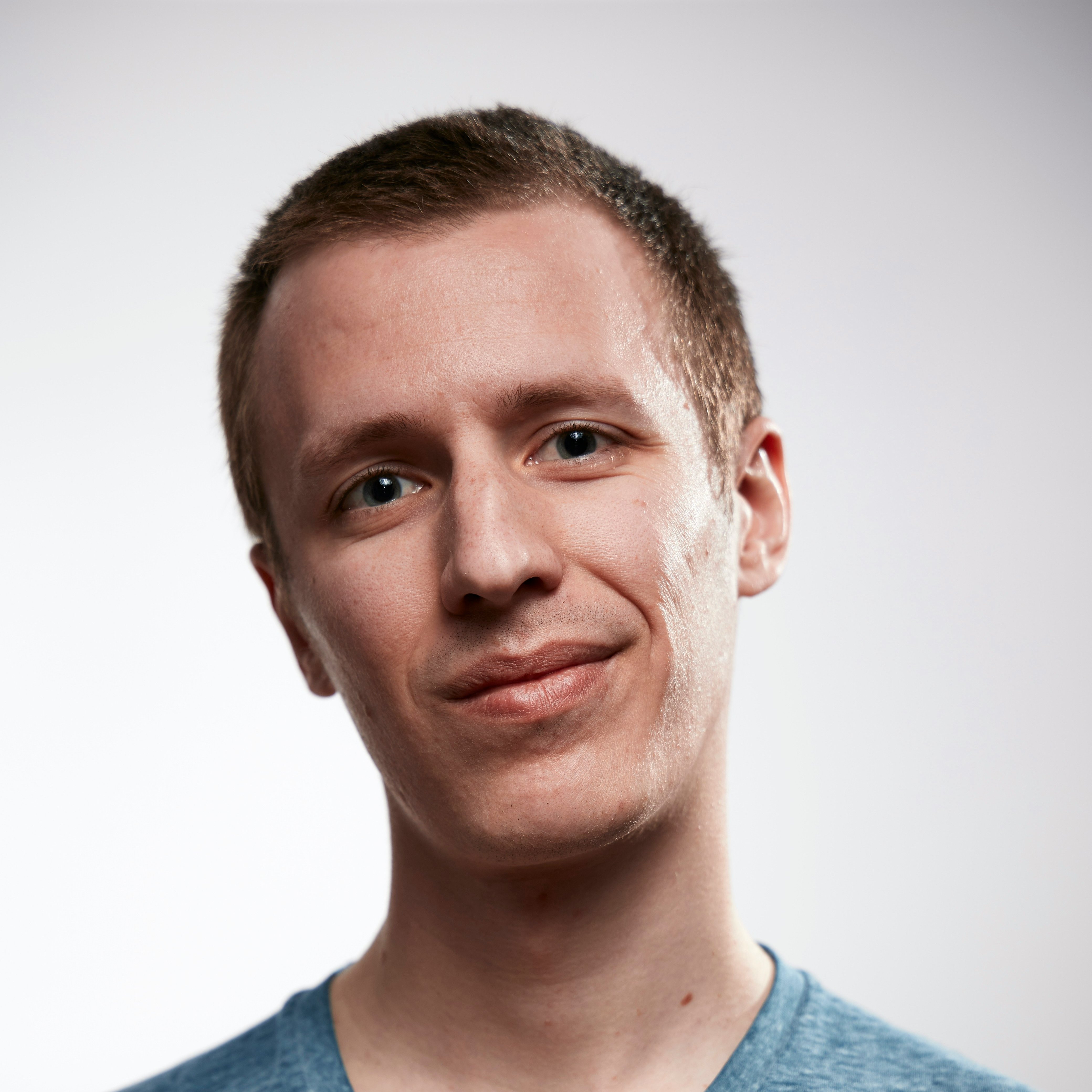 Portrait of a smiling man in casual blue shirt on a white background. Self portrait taken to test a brand new EOS RP.