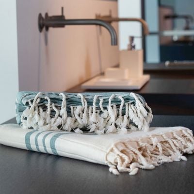 Krem Sultan hamamdoeken opgevouwen in een wellness badkamer, ideaal voor sauna en ontspanning