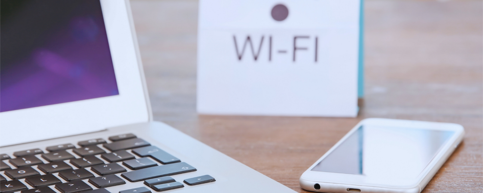 laptop met telefoon op bureau en bordje wifi