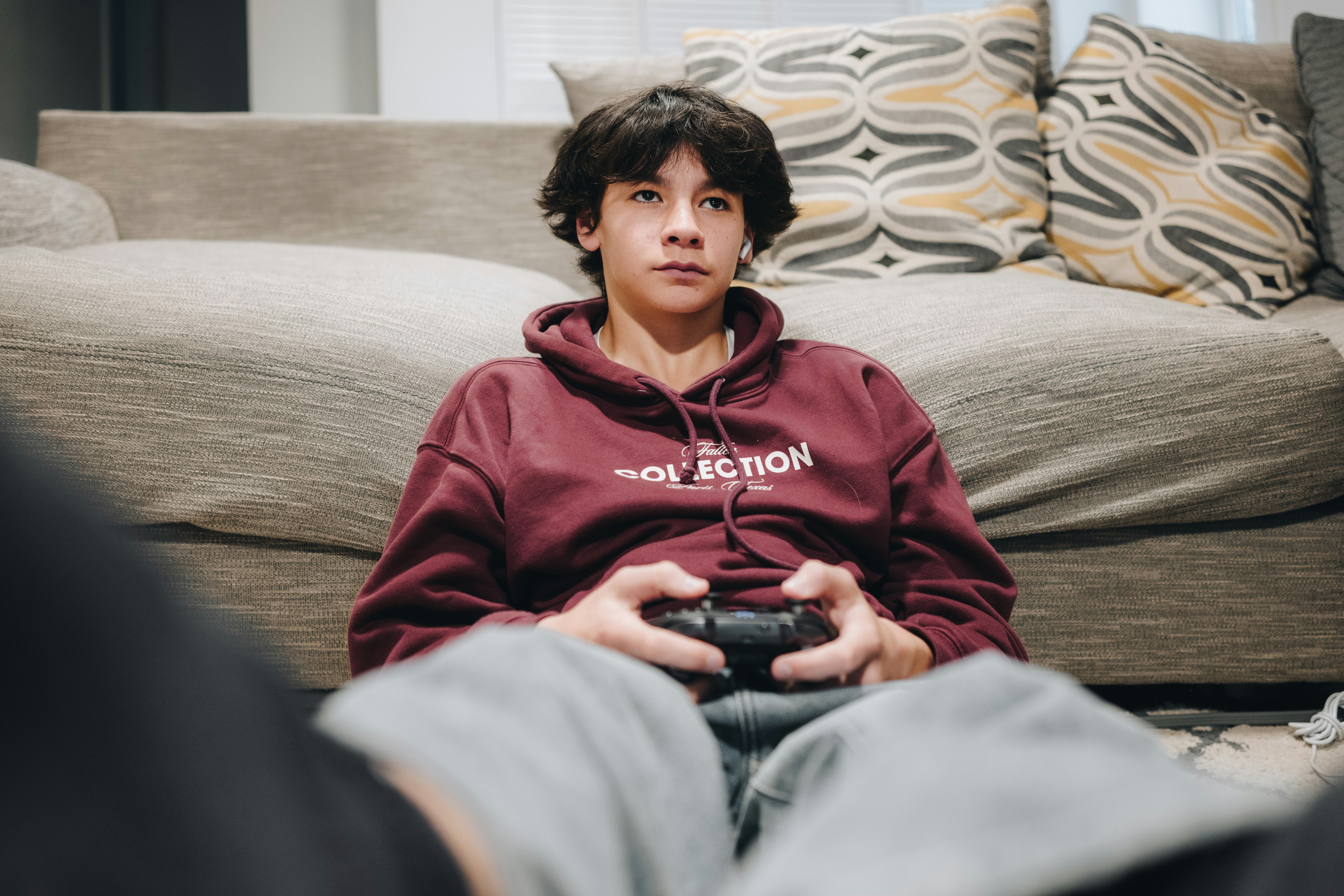 Teen gaming at home in his living room.