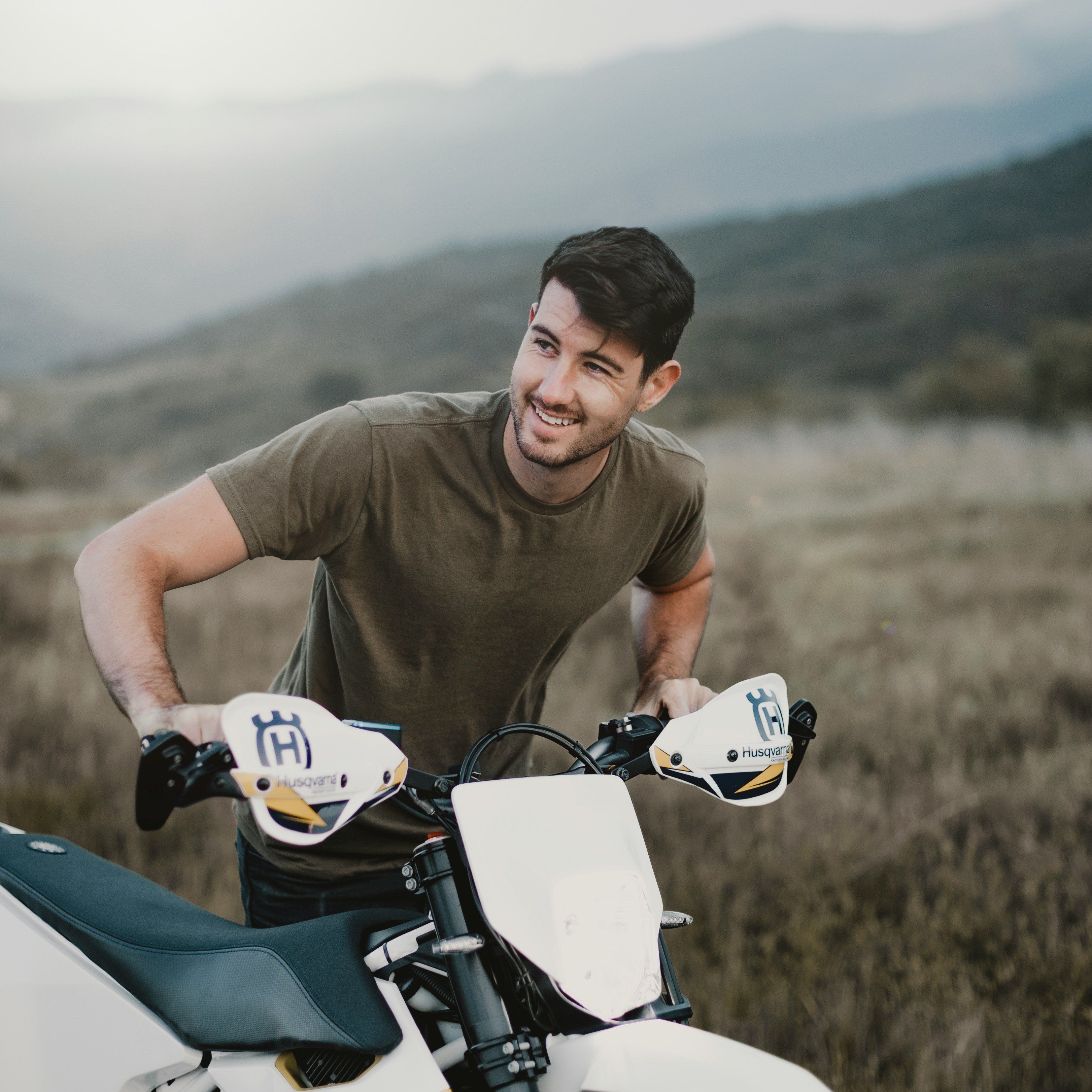 Man pushing motorcycle up hill