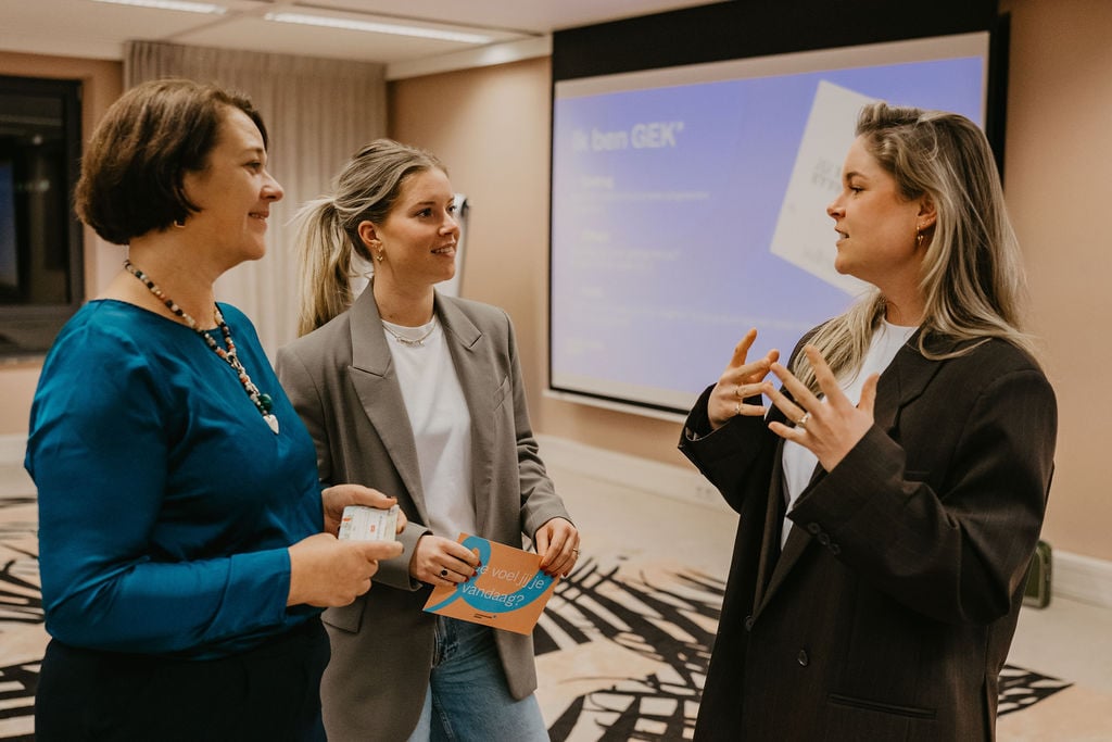 Vrouw in een kleurrijke setting die vol aandacht luistert, symbool voor effectieve en persoonlijke communicatie.