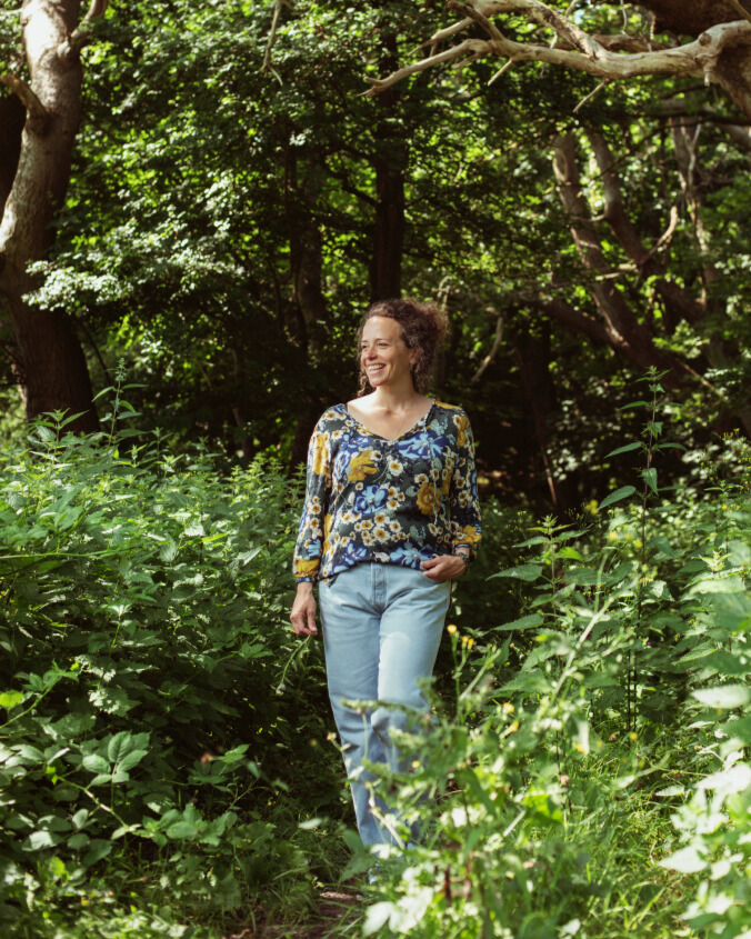 persoon loopt in groen tussen de bomen