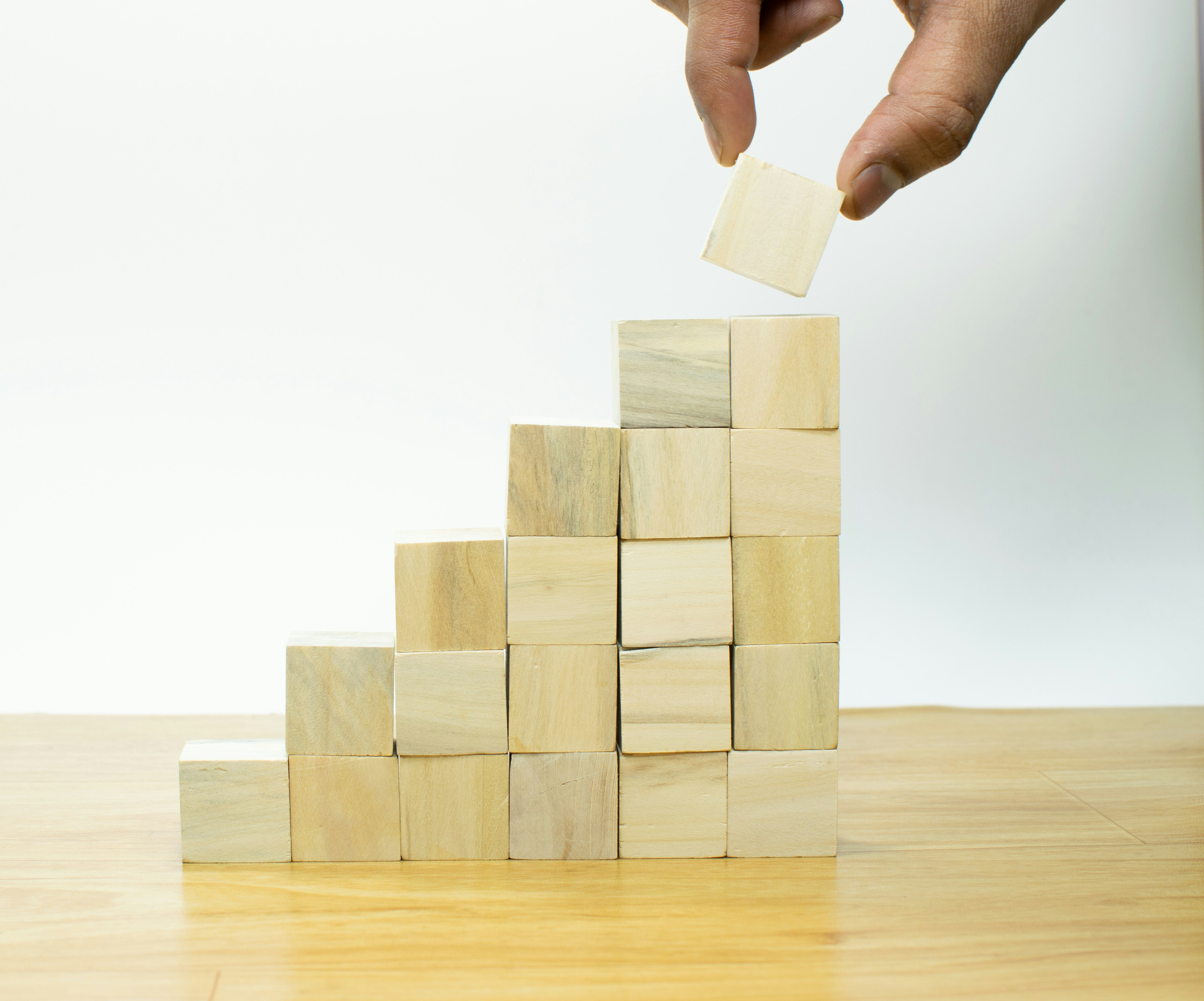 Businessman hand putting blank wooden cube block stack on white background with copy space for input text, icon, trend, creative idea, finance, leadership, strategy, business, online marketing concept
