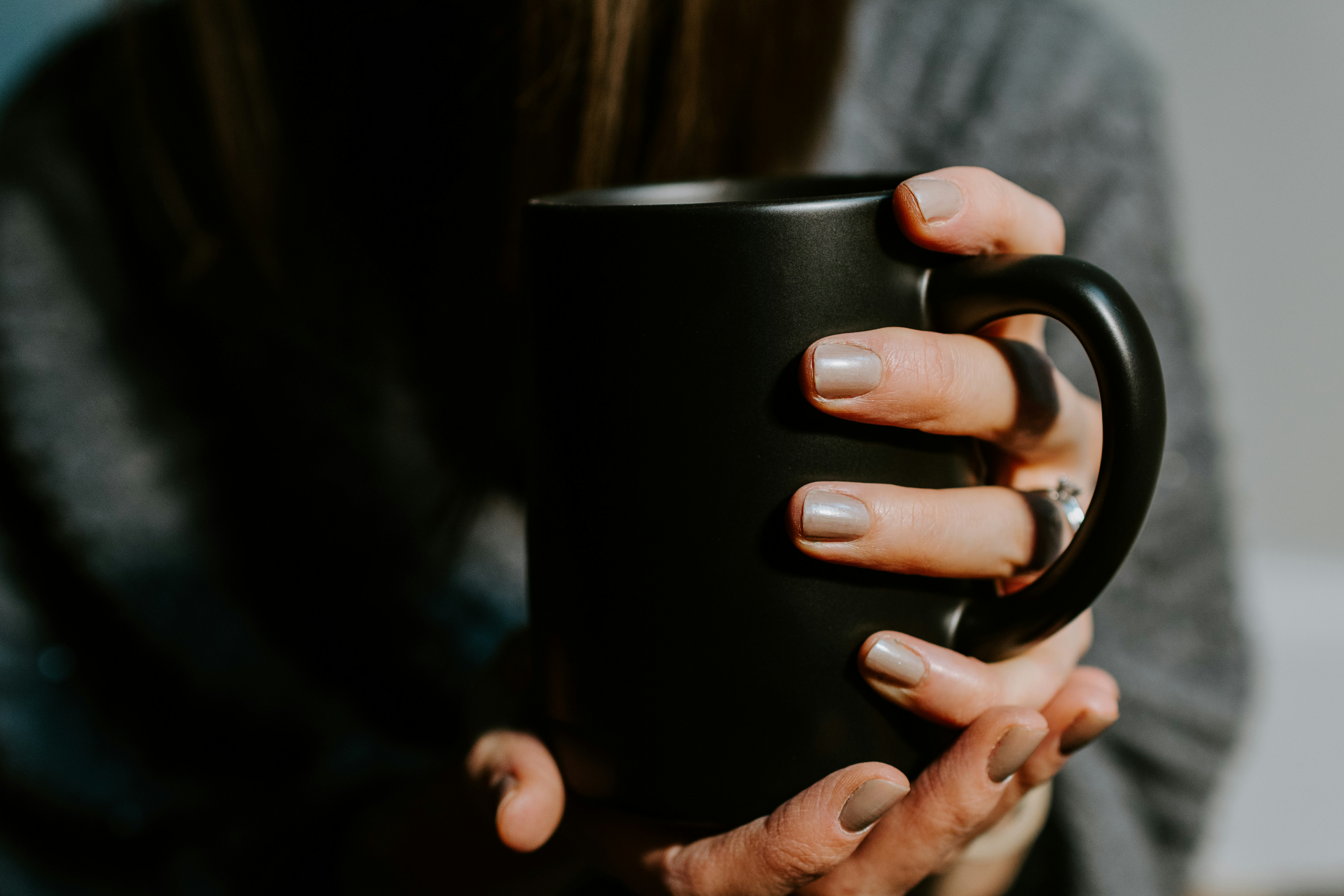 Woman's hands holding black mug