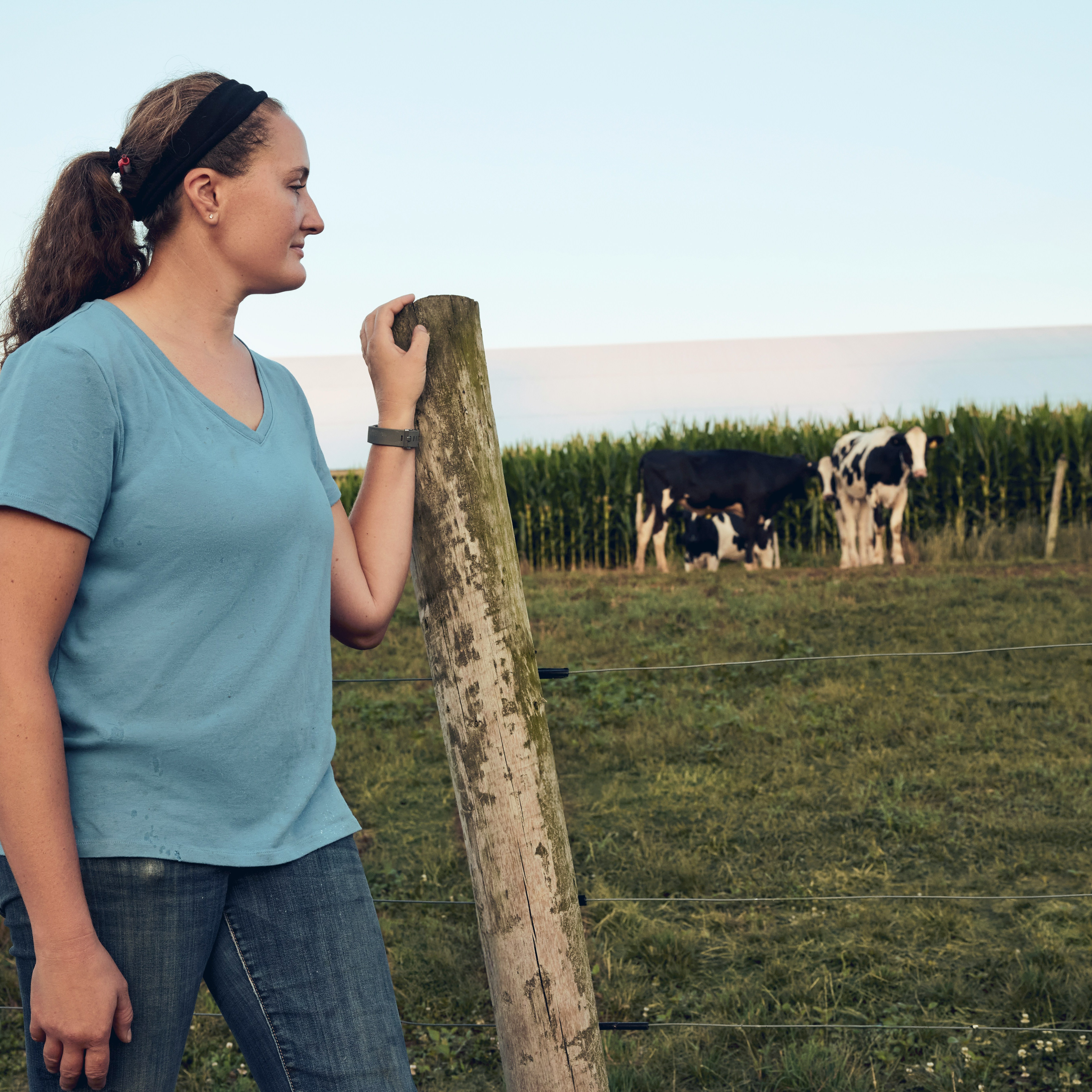 Woman beside a pasture fence. Pennsylvania, USA.
