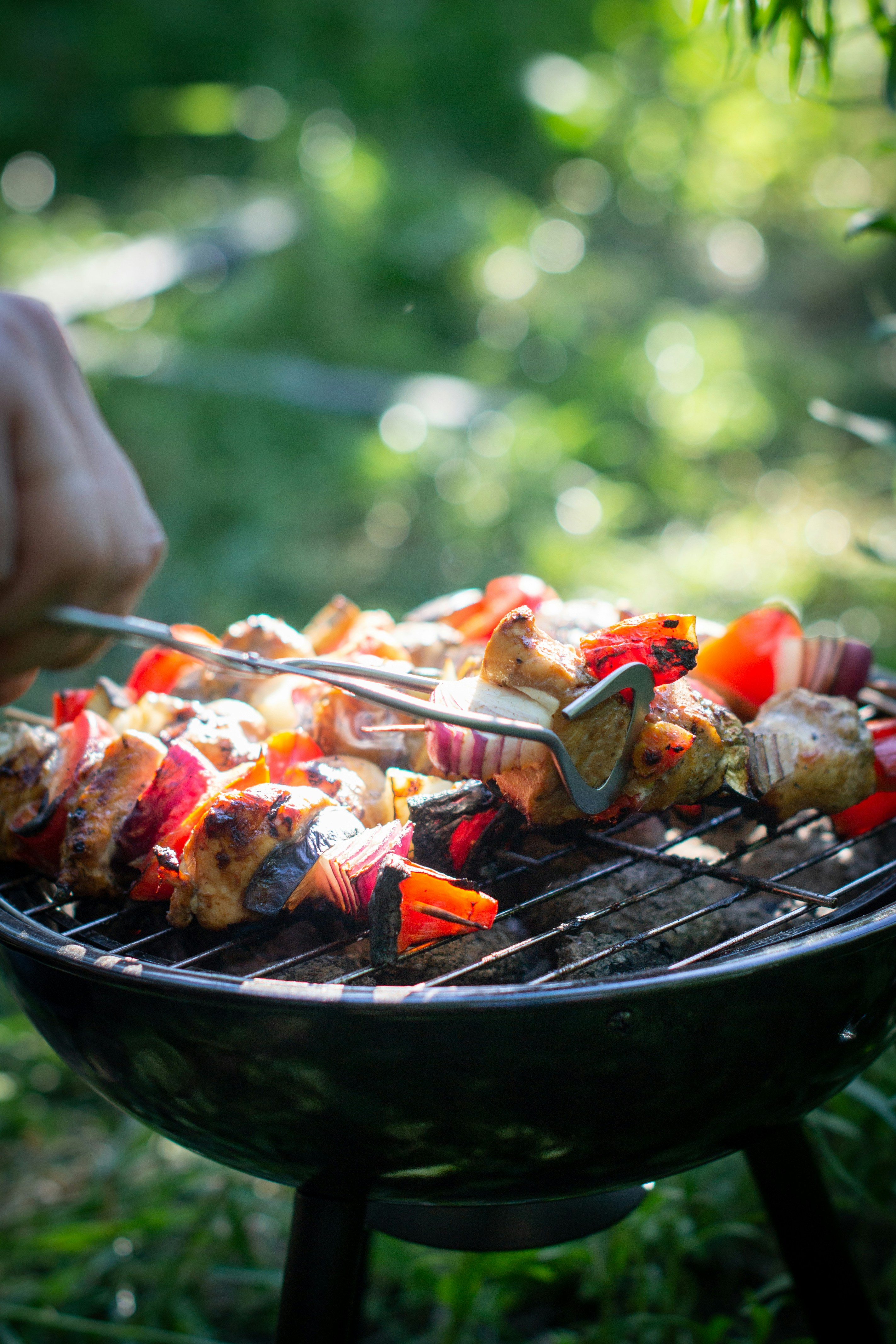 Grilling skewers or kebabs on a kettle-style BBQ or barbecue