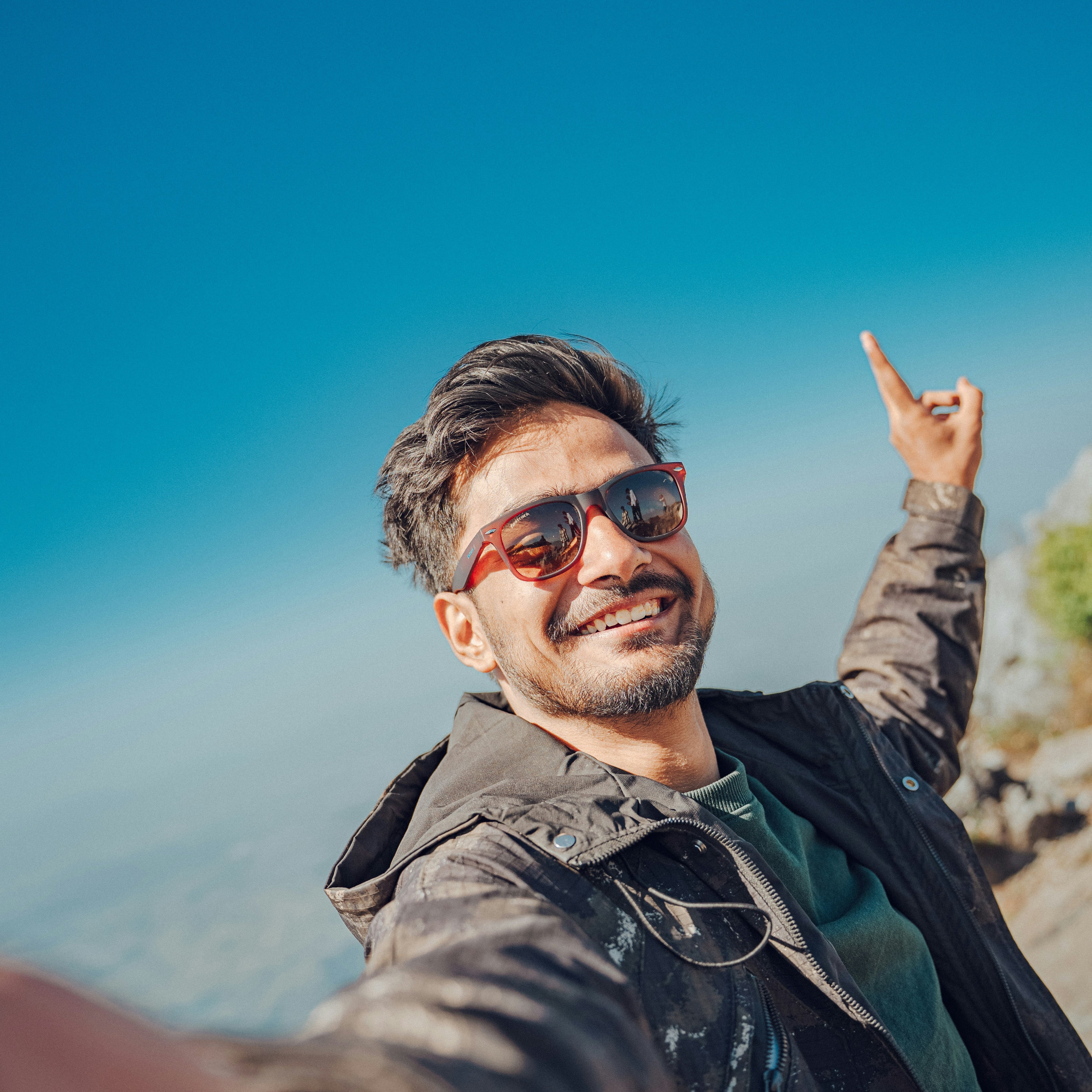 Man standing in the mountains surrounded by scenic landscape, capturing a moment of peace, travel, and adventure. Concept of nature, exploration, freedom, and outdoor lifestyle.