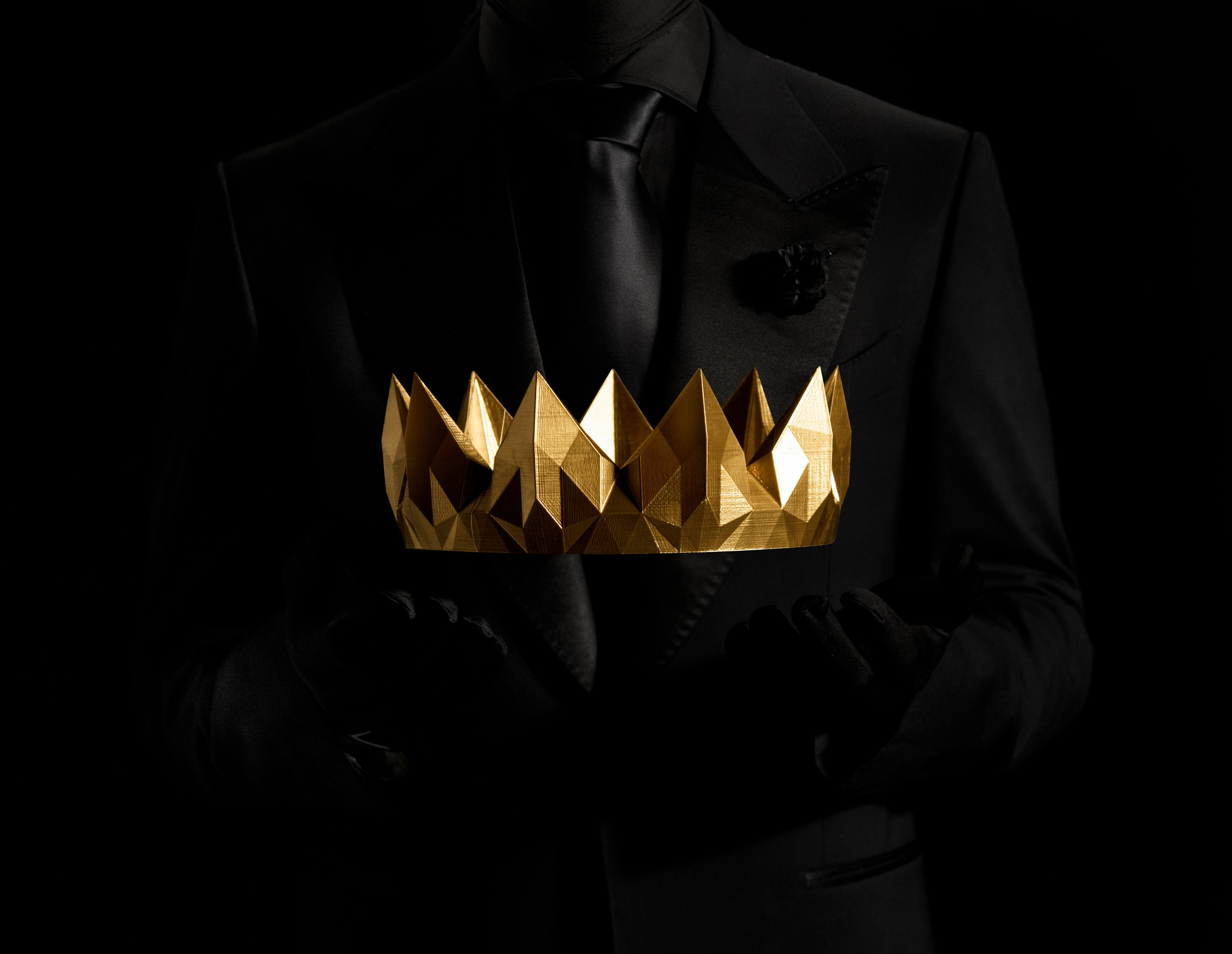 Silhouette holding gold crown