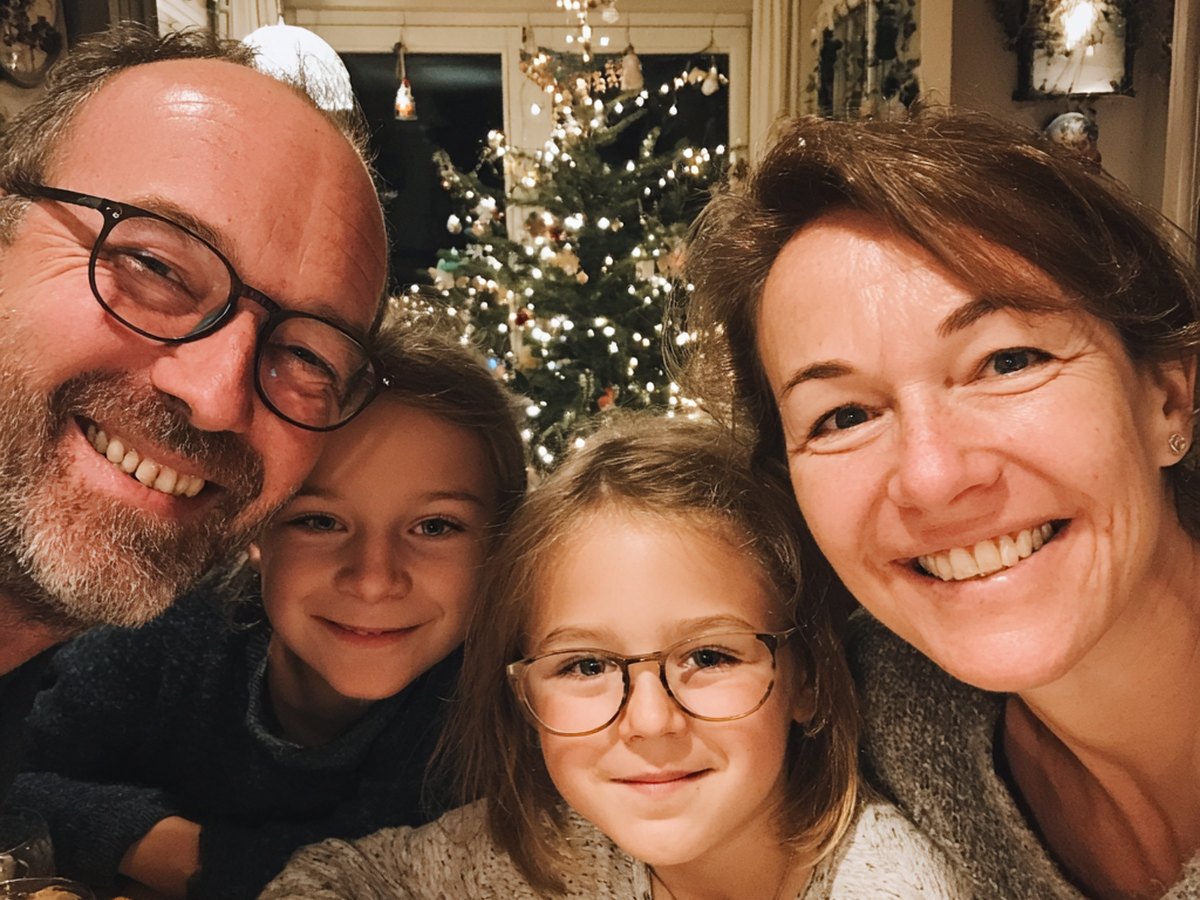 Gezin maakt een selfie bij de kerstboom tijdens een kerstspel